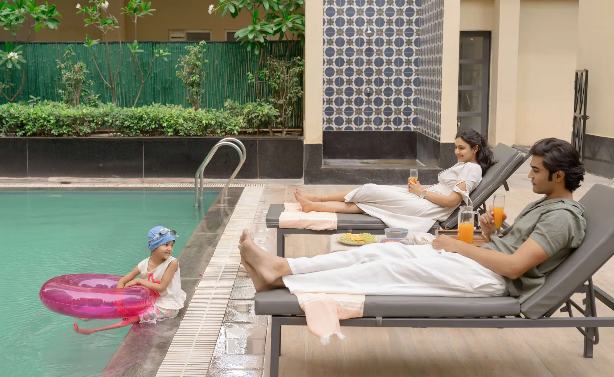 A family relaxing on loungers by the swimming pool