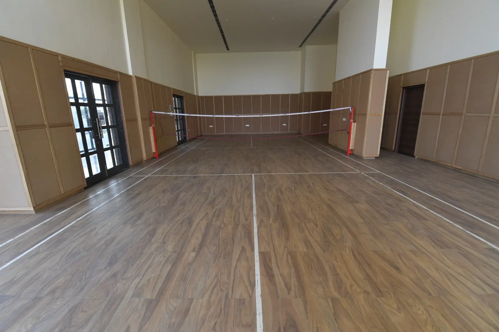 Wood-floored multipurpose hall with a badminton net